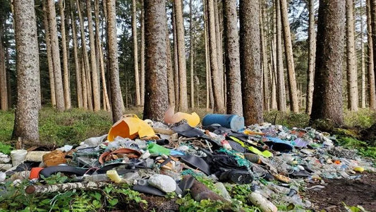 A forest scene with a large pile of trash—highlighting the dangers of nano plastics and their impact on the environment and human health.