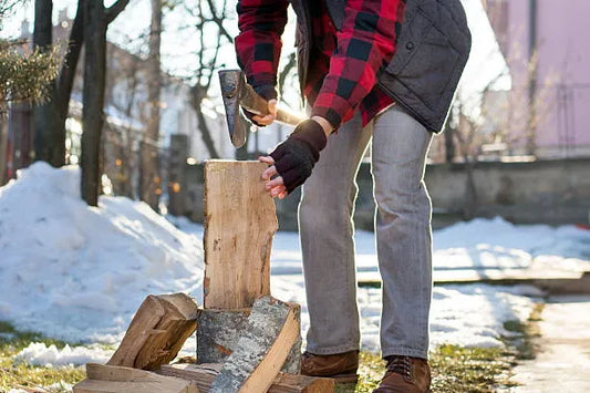 A man chopping wood in the winter, breaking through the winter blues—symbolizing the power of physical activity to boost mood and combat seasonal challenges.